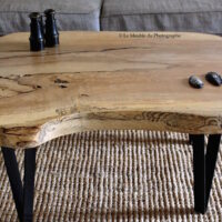 Table basse frene bois massif forme arrondie. Sur pieds métal peint en noir. Motifs originaux. Bois français. Artisanat local.