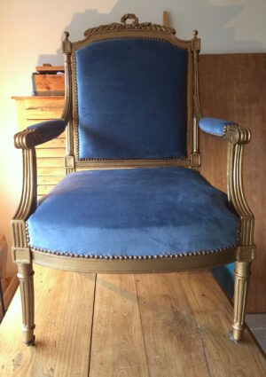 Fauteuil Napoléon III après réparation. Tapisserie d'ameublement bleu. Peinture or. Atelier artisanal.