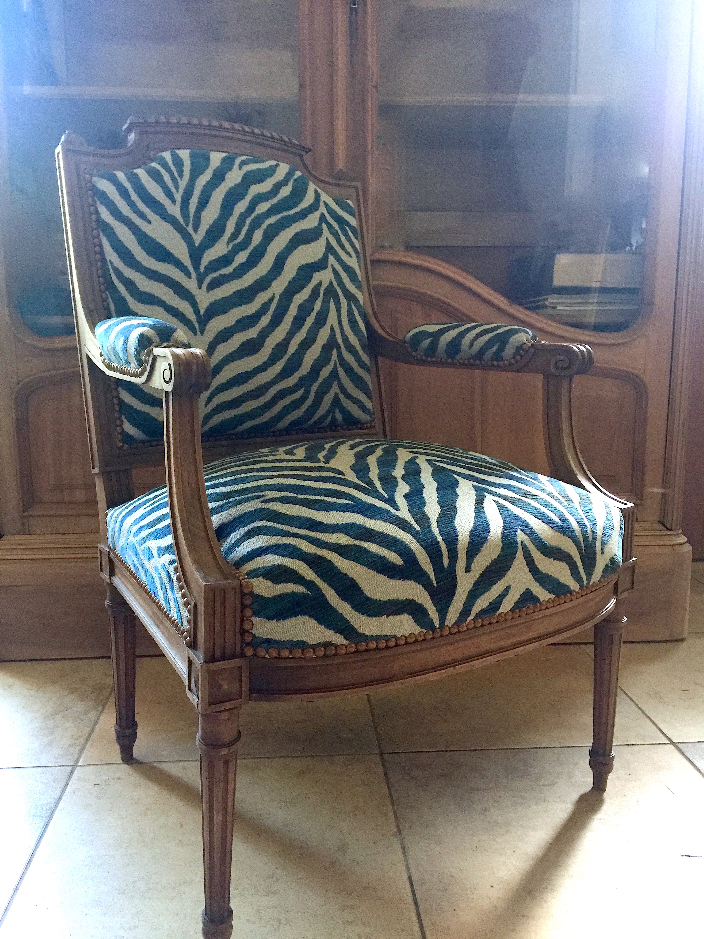 Fauteuil ancien retapissé motif zèbre bleu.