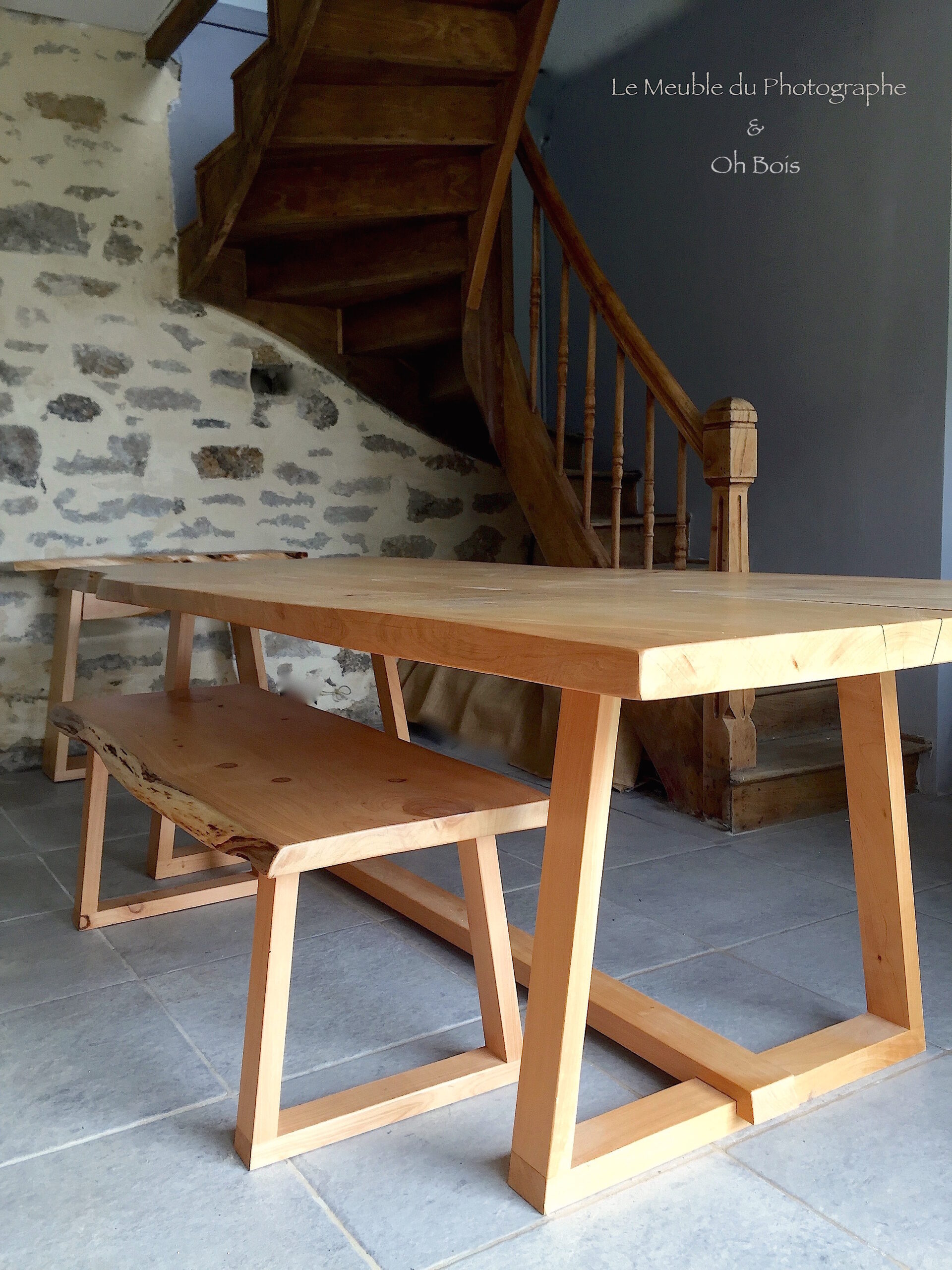 Grande table en bois massif sur mesure. Pieds triangulaires en bois. Avec son banc assorti en bois; travail artisanal mobilier en bois sur mesure.