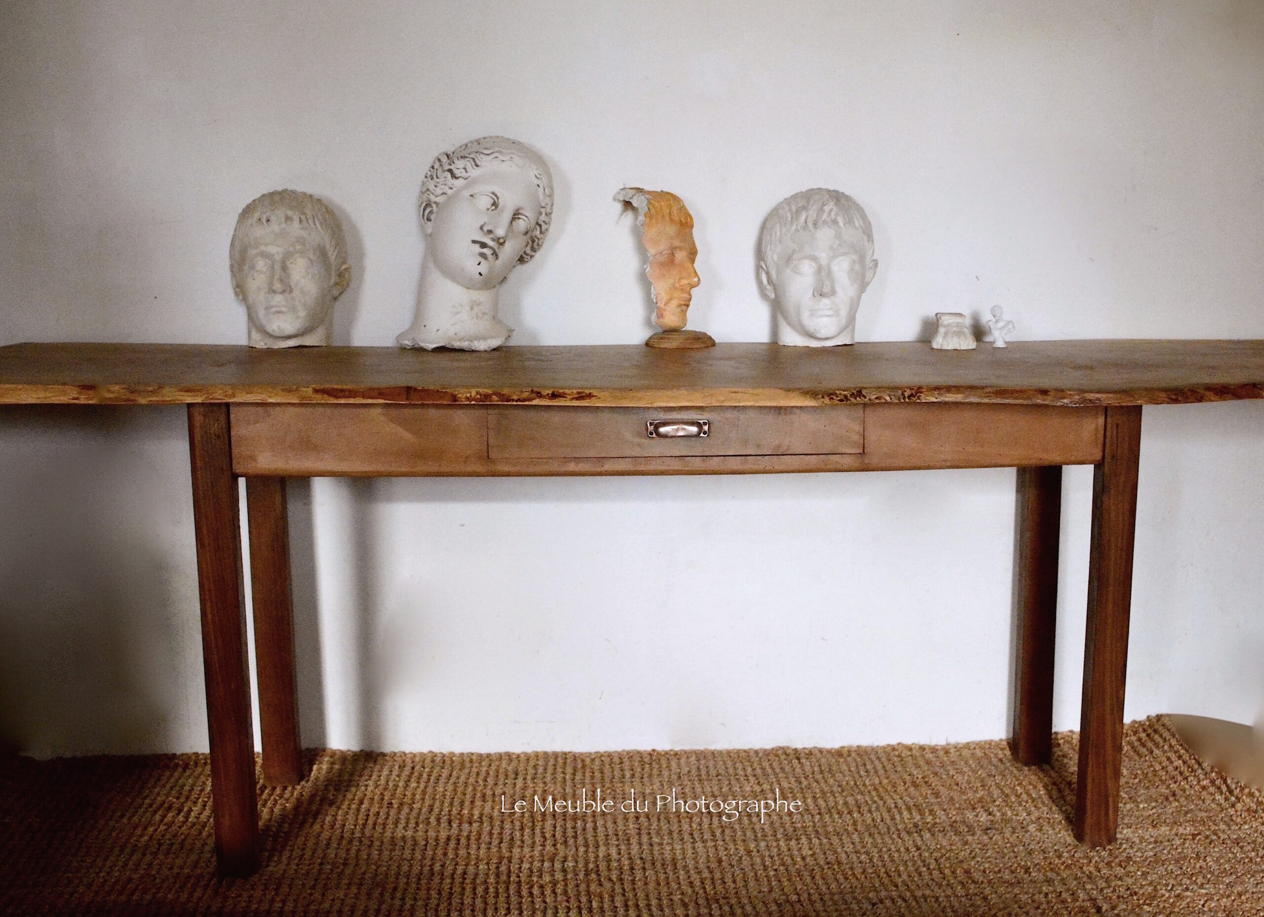 console en bois massif: planche de frêne sur meuble de métier ancien, avec têtes sculptées en plâtre en déco. Style atelier d'artiste.